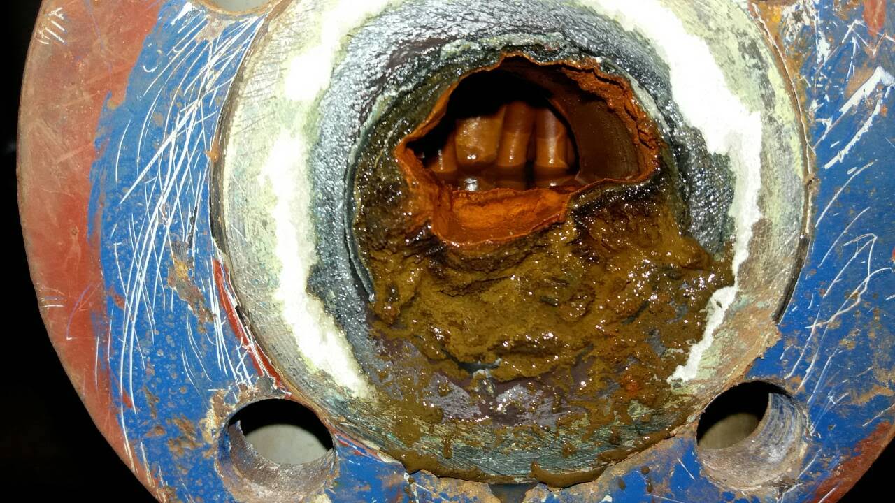 Wnętrze wymiennika ciepła zalane szlamem i magnetytem — typowy obraz zaniedbanej instalacji CO